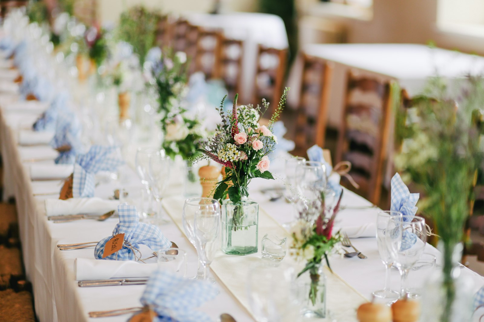 Elegant beach wedding setup with white chairs and floral arch on a Dubai beach at sunset
