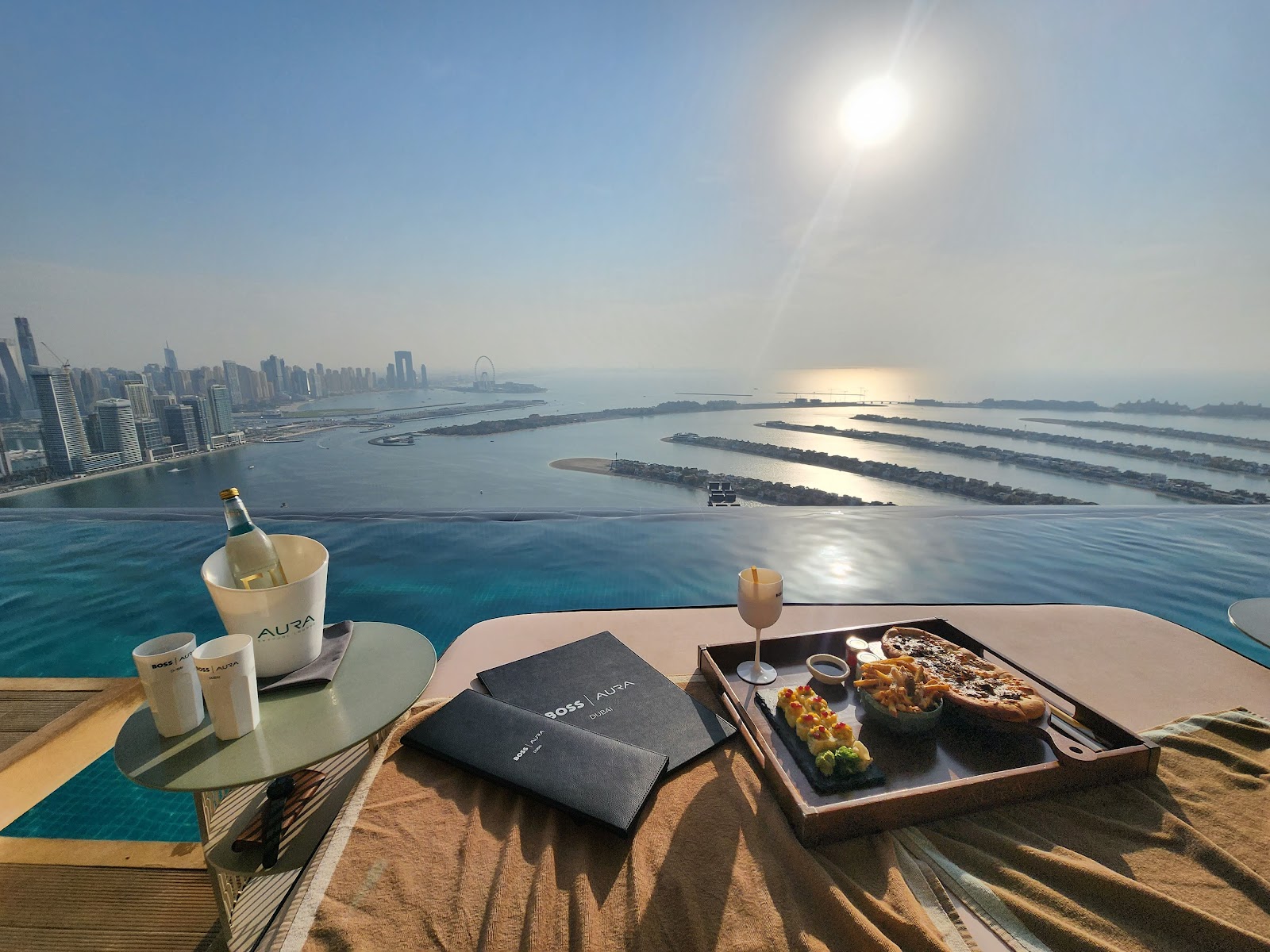 AURA Skypool Dubai — luxury infinity pool at sunset with city views from Palm Tower 210m high
