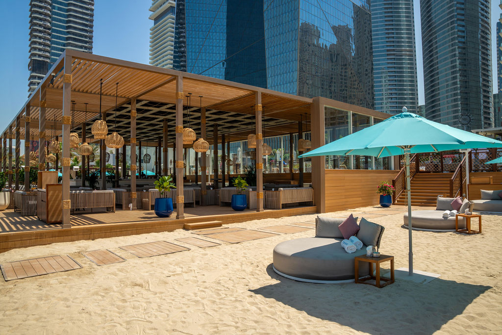 Rooftop infinity pool in Dubai with misting fans and shade structures during summer