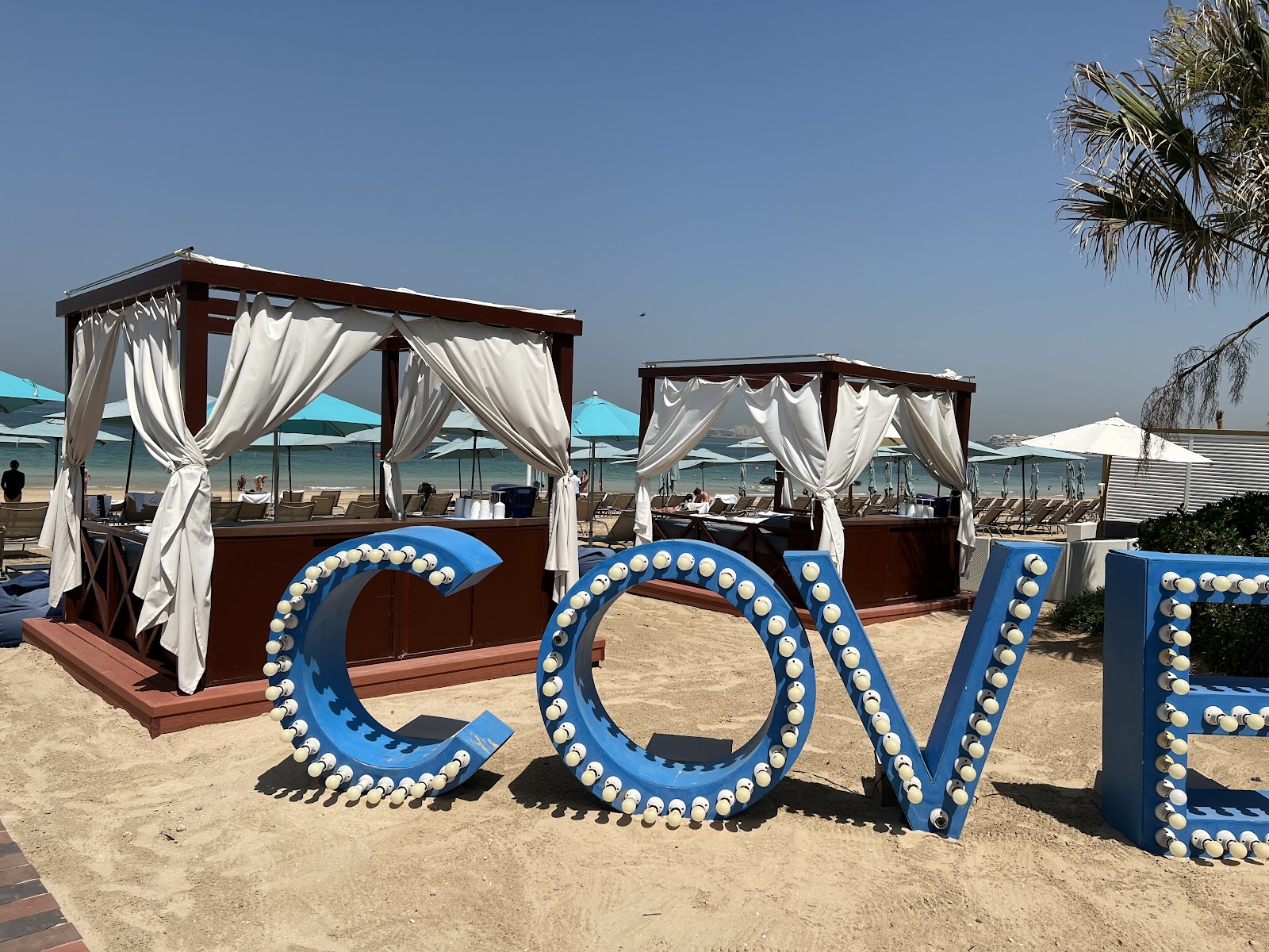 Cove Beach Bluewaters Island Dubai — Mediterranean-style beach club with white sunbeds and Ain Dubai world's largest Ferris wheel backdrop