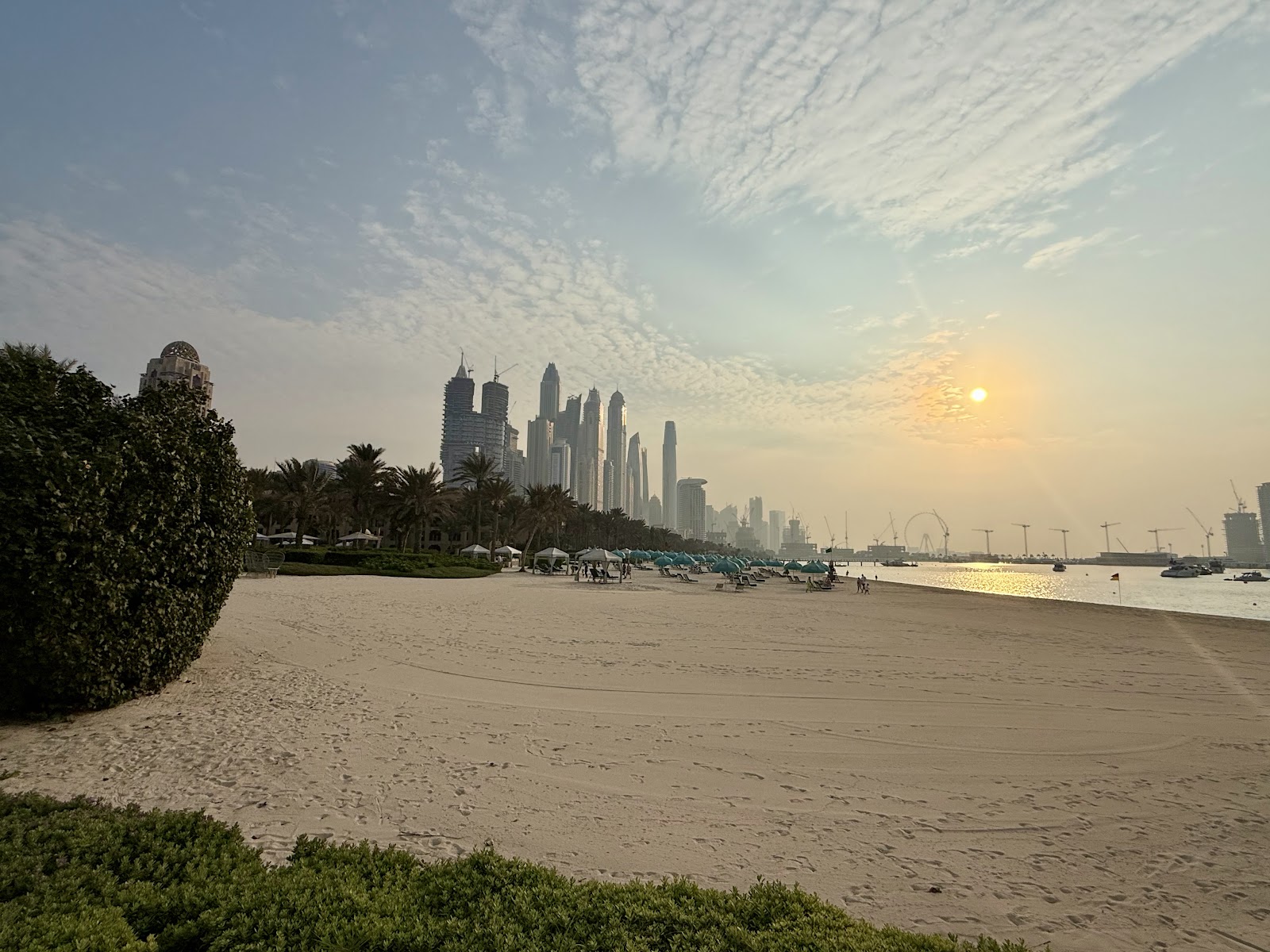 Private cabana with white curtains and sun loungers at Dubai beach club