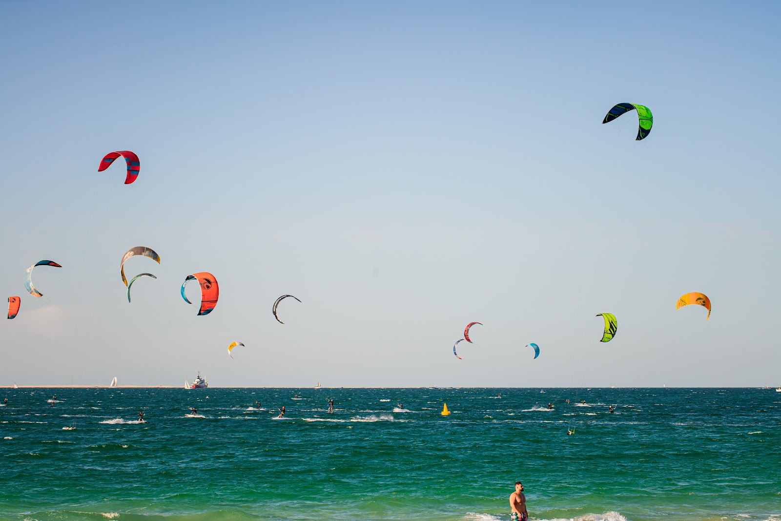 Kite Beach Dubai public beach — golden sand shoreline with Burj Al Arab hotel silhouette on the horizon in Umm Suqeim