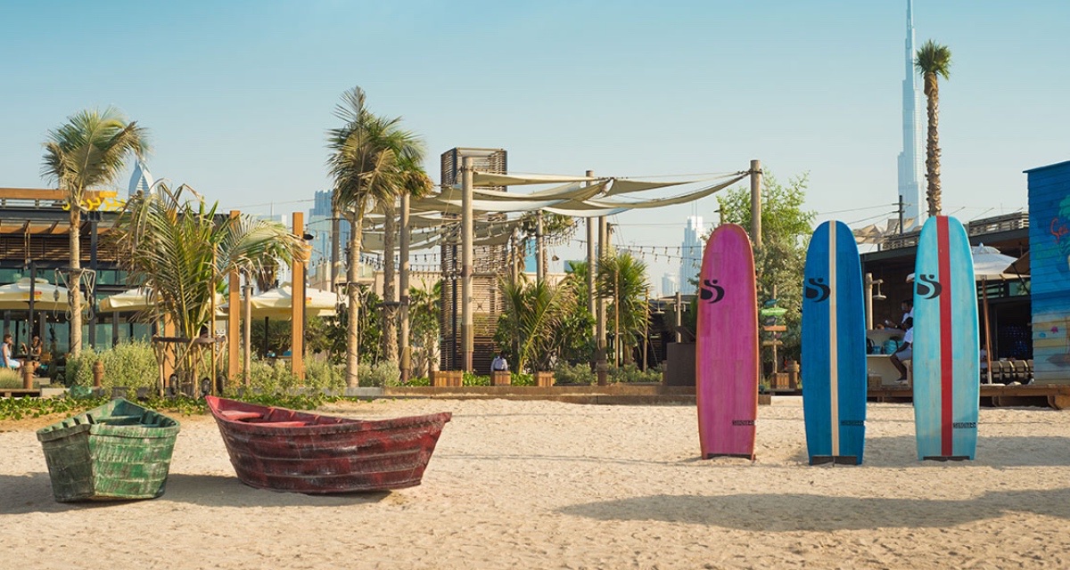 Jumeirah Beach Dubai — golden sand and turquoise water with the iconic Burj Al Arab silhouette on the horizon at Kite Beach