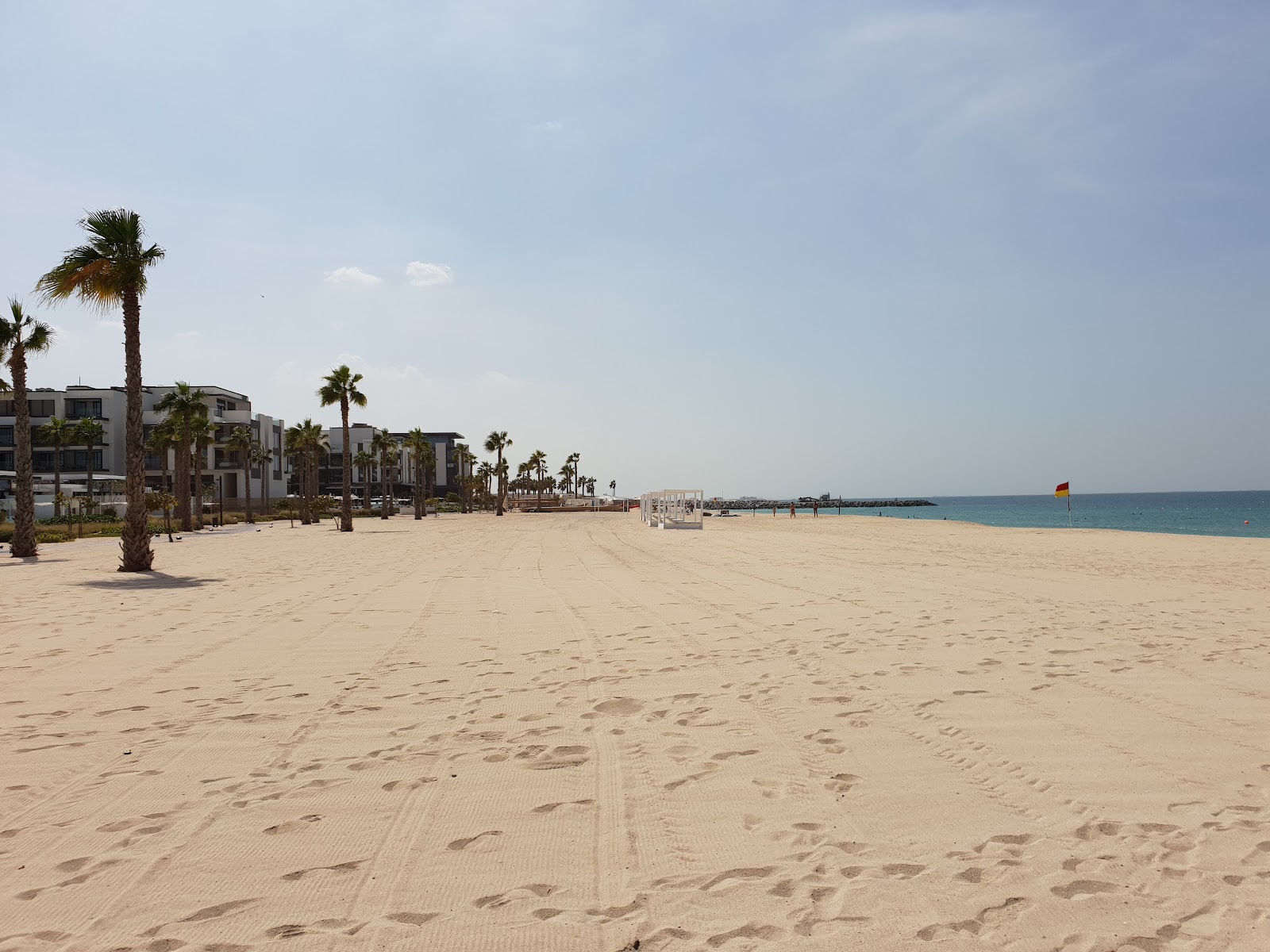 Nikki Beach Dubai outdoor pool with white sun loungers and private beach, Pearl Jumeirah