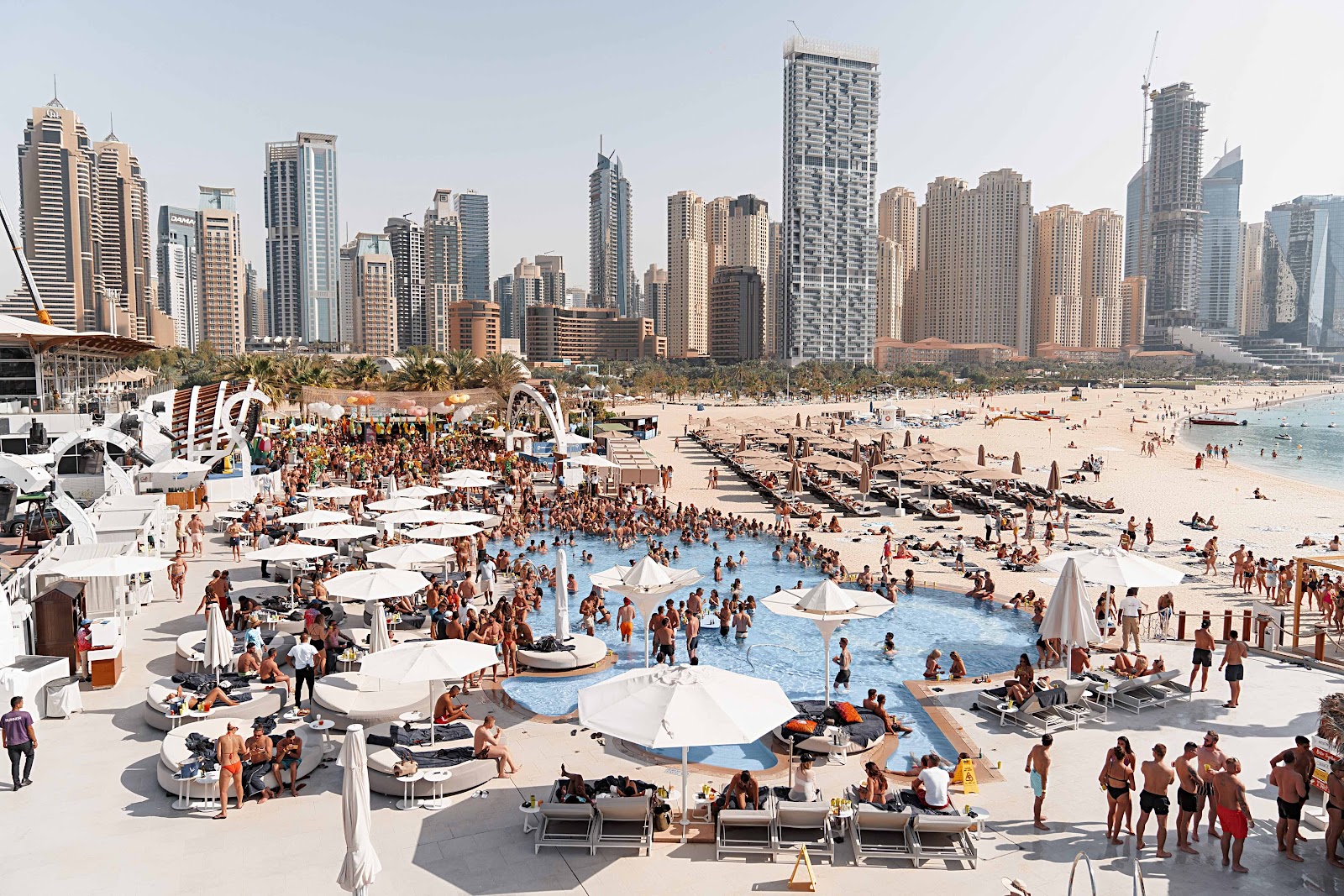 Dubai Marina and JBR Beach aerial view — The Walk promenade, high-rise towers and turquoise Arabian Gulf beach